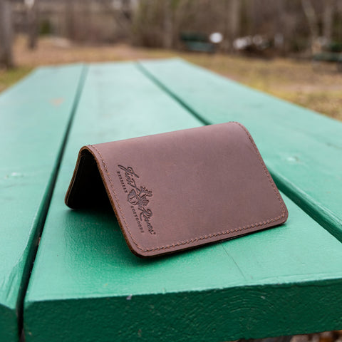 Leather Pocketfolio sits on a green wooden picnic table outside. 