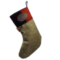 A Christmas stocking with a textured olive green body, a red and patchwork cuff, and a brown leather logo patch on the side.