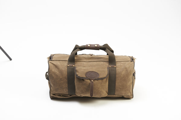 Waxed canvas duffle bag with cotton webbed grab handles and shoulder strap.
