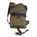 Front view of sling pack shown with open flap to see large front zipper pocket and a cord and barrel tie down system for a jacket or blanket