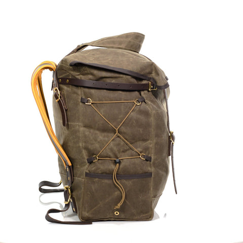 Top leather straps run horizontal around the sides of the top part of the lid and connect to brass buckles to cinch the opening down before placing the top flap over for additional security.